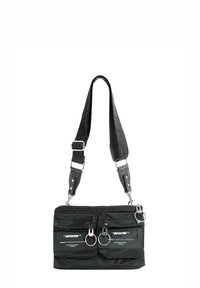 Bolso de hombro negro hecho de nailon con herrajes plateados. Cuenta con dos bolsillos frontales, una cremallera superior y una correa desmontable.