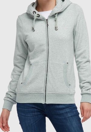 Light gray zip-up hoodie with drawstrings and front pockets worn over a white shirt and blue jeans on a standing person.