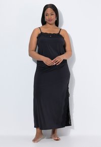 Zwarte maxi-jurk met een cami-top van gladde stof, voorzien van kantaccenten langs de halslijn en zijkanten, met dunne bandjes en een losse pasvorm.