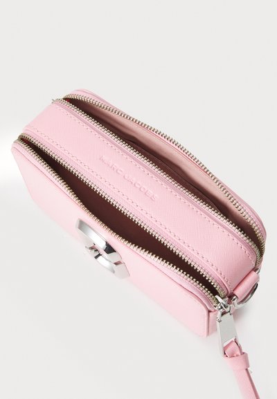Pink zippered pouch made of textured material, featuring silver hardware, dual zipped compartments, and embossed logo inside.