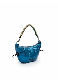 Sac à main bleu en peluche avec une bandoulière tressée multicolore, présentant une surface brillante texturée et des cordons de serrage sur les côtés. Accents en métal noir.