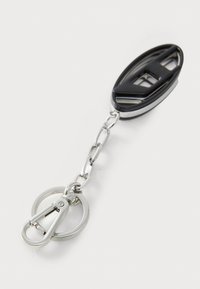 Portachiavi nero con clip circolare in argento, dotato di un attacco ovale con un design a ritaglio e una finitura lucida e liscia.