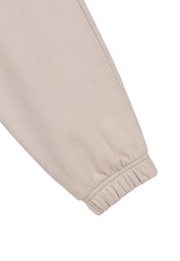Beżowe spodnie dresowe z elastycznym mankietem, miękką teksturą i gładkim wykończeniem. Prosty krój bez widocznych wzorów czy akcentów.