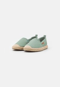 Grønne lerretsespadrillos med en vevd jutesåle og rund tå, med et lite merke på siden og slip-on design.