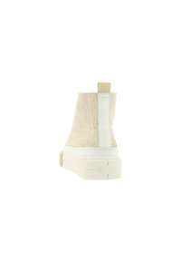 Beige enkelboot met een gestructureerde stof bovenkant, witte rubberen zool en een contrasterende tab aan de achterkant voor gemakkelijk aan- en uittrekken.