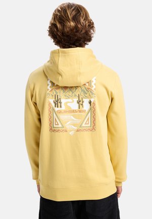 Yellow hoodie made of cotton, featuring a graphic design with mountains, cacti, and geometric patterns on the back. Soft texture and fitted sleeves.
