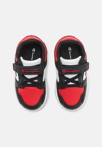 Červeno-černo-bílé sportovní boty s syntetickým svrškem, suchým zipem a šněrováním; mají perforovaný červený detail na špičce.