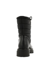 Botas negras hasta el tobillo con parte superior acolchada, parte inferior de cuero, suela de goma texturizada y un tirador para facilitar el calzado y descalzado. Diseñadas para brindar comodidad y calidez.