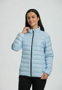 Giacca imbottita azzurra chiara con colletto alto, motivo a righe verticali e zip frontale. Presenta polsini elasticizzati e tasche laterali.