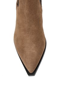 Brązowy zamszowy botek do kostki z ostro zakończonym czubkiem i czarną podeszwą. Powierzchnia ma miękką teksturę i nie ma widocznych wzorów ani elementów metalowych.
