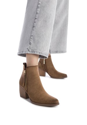 Botas de tobillo de ante marrón con punta afilada y tacón cuadrado. Presenta una cremallera lateral y un tacón texturizado para mayor estabilidad.