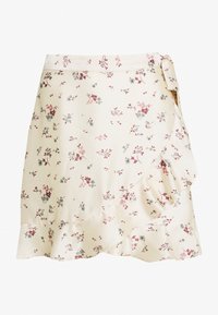 Jupe à motif floral en crème, ornée de petites fleurs rouges et bleues, au design enveloppant avec un ourlet froncé et un détail de lien sur le côté.