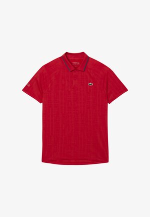Polo rosso in tessuto texture, con un motivo sottile, maniche corte, un colletto colorato e un logo Lacoste verde sul petto.