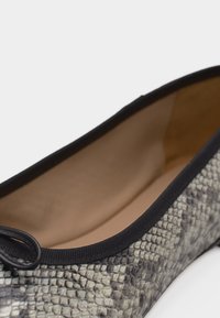 Γυναικείο μπαλαρίνα παπούτσι με γκρι και μαύρο σχέδιο δέρματος φιδιού, μαύρο περίγραμμα και μικρό διακοσμητικό φιόγκο στη μύτη.