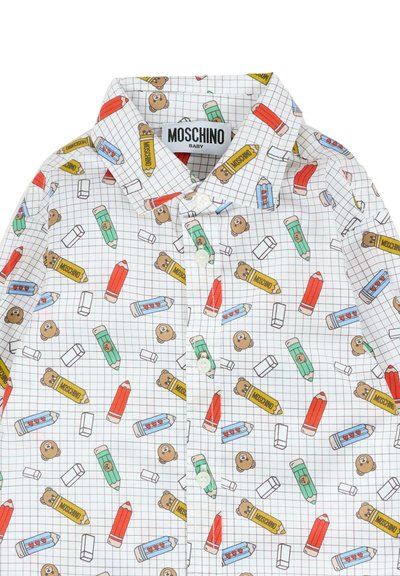 Maglietta bianca per bambini con motivo a griglia, decorata con illustrazioni colorate di matite, gomme e orsetti, e un'etichetta Moschino sul colletto.