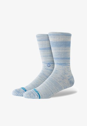 Hellblaue Knöchelsocken mit gestreiftem Muster und strukturierter Oberfläche. Blaue Akzente an der Spitze und ein rundes Logo an der Seite.