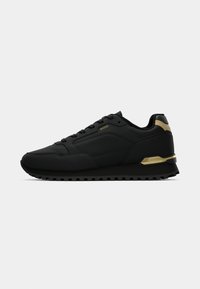 Sapatilhas desportivas pretas com material sintético suave, design aerodinâmico, detalhes em dourado no calcanhar e sola de borracha preta texturizada.
