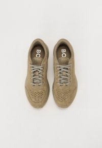 Sneaker in suede beige con lacci grigi, dettagli perforati sulla punta e suola in gomma. Logo "BOSS" sulla linguetta. Design piatto e strutturato.