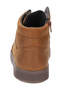 Baskets montantes en cuir brun avec une surface texturée, doublure noire, fermeture éclair sur le côté et semelle en caoutchouc avec des rainures horizontales.