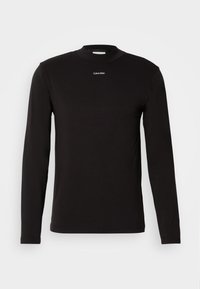 Musta pika varrukaga särk, mis on valmistatud siledast puuvillast. Omab kõrget kaelust ja väikest valget logo rinna piirkonnas. Slim-fit disain.