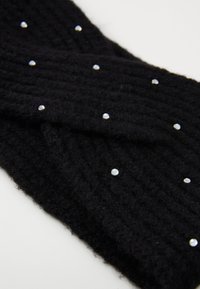 Fascia di lana nera lavorata a maglia con una texture a costine e accenti di gemme trasparenti sparse per un dettaglio decorativo.