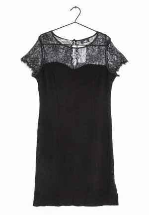 Robe noire avec des manches courtes en dentelle, corsage ajusté et décolleté rond. Elle présente une fermeture à boutons dans le dos et un tissu lisse à texture mate.