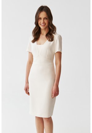 Figurbetontes, knielanges Kleid aus cremefarbenem Stoff; mit kurzen Ärmeln und einem quadratischen Ausschnitt sowie schrägen Nähten für zusätzliche Designdetails.