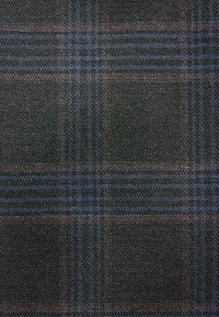 Tartanstoff in Dunkelgrün und Schwarz mit blauen und lila Linien. Strukturiertes Gewebe mit klassischem Karomuster.