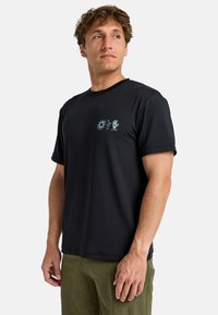 Camiseta ligera negra con cuello redondo, que presenta un gráfico azul con diseños de sol y mano en el pecho. Mangas cortas, tela texturizada.