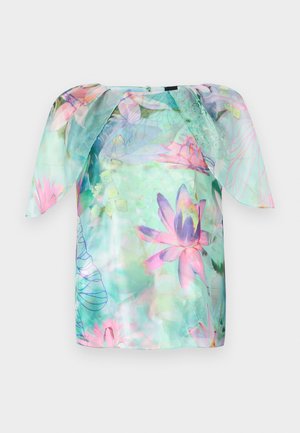 Blouse à manches courtes en tissu léger et transparent, ornée d'un motif floral aquarelle dans des nuances de rose et de bleu, avec un col rond et une coupe ample.