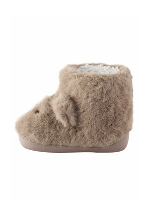 Soft, fuzzy beige baby slipper shaped like a bear with ears, embroidered eyes, and a white fleece lining inside.