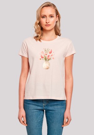 Helles rosa Baumwoll-T-Shirt mit kurzen Ärmeln, das in der Mitte ein florales Design mit rosa Tulpen in einer Vase zeigt. Lässiger Schnitt, runder Halsausschnitt.
