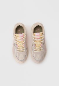 Helle beigefarbene Sneakers aus Mesh und Wildleder, mit strukturierten Details in Grau und Pink, runder Zehenpartie und flachen Schnürsenkeln.