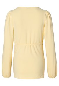 Geel langermouw top met een ronde halslijn, gathered pofmouwen en een aansluitende tailleband voor een goede pasvorm. Zachte, gladde textuur.