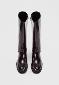 Βουργουνδία δερμάτινες μπότες μέχρι το γόνατο με γυαλιστερό φινίρισμα, κλείσιμο με φερμουάρ, ανατομικό σχέδιο και χοντρή μαύρη σόλα.