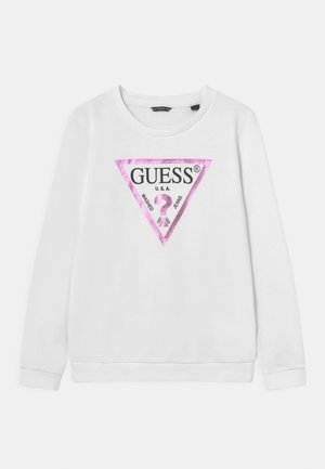 Weißer Sweatshirt mit langen Ärmeln und rundem Ausschnitt, versehen mit einem pinken und schwarzen Dreieckslogo sowie dem Text "GUESS" und "WASHED JEANS".