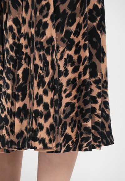 Leopardmønstret plisseret nederdel i lysebrun og sort stof, der fremviser tekstur- og mønsterdetaljer i et flydende design.
