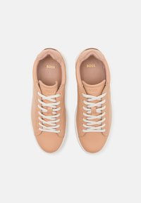 Ροζ δερμάτινα αθλητικά παπούτσια με λευκές κορδόνες και καουτσούκ σόλες. Διαθέτουν λογότυπο "BOSS" σε χρυσό στην γλώσσα και στα πλάγια. Λείο υλικό.