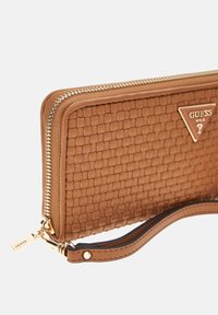 Portafoglio in pelle intrecciata marrone con zip e hardware dorati, caratterizzato da un dettaglio a triangolo e una tracolla per maggiore comodità.
