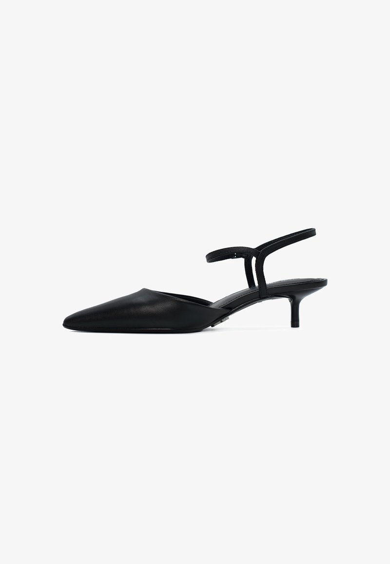 Chaussure slingback noire avec un bout pointu et un talon fin. Fabriquée en cuir lisse, elle présente une sangle minimaliste et un design épuré.