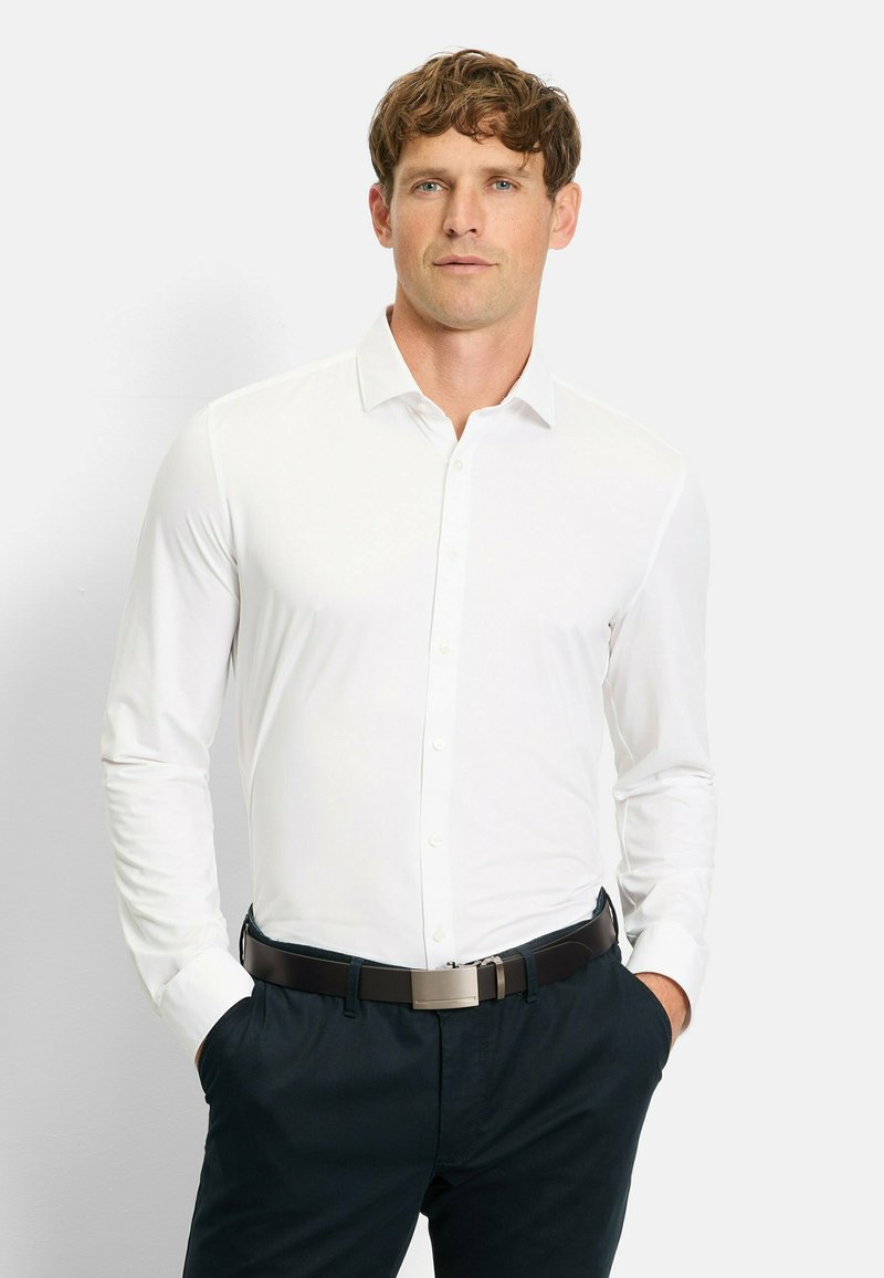 Weißes Langarmhemd mit Slim-Fit und klassischem Kragen. Kombiniert mit dunkelblauen Hosen und einem dunklen Gürtel. Glatte Textur.