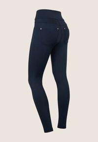 Leggings de cintura alta en color azul marino con una textura suave, costuras planas y dos bolsillos traseros. Presentan sutiles acentos metálicos cerca de los bolsillos.