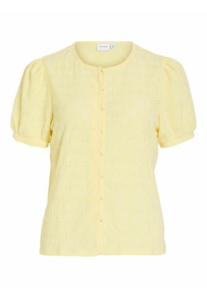 Blouse jaune à manches courtes avec col rond, boutonnage devant, manches bouffantes et motif brodé à œillets floraux.