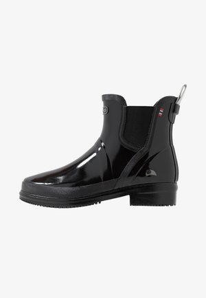 Botte de pluie noire brillante à la cheville avec panneaux latéraux élastiques, languette au talon et semelle texturée pour une bonne adhérence.