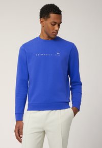 Heldblau sweatshirt met ronde hals, lange mouwen en geribde manchetten. Voorzien van bedrukte logo tekst en een eenvoudig ontwerp.