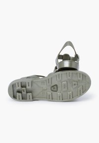 Olive green sandal with a textured rubber sole, adjustable strap, and cut-out design. Features traction patterns on the sole for grip.