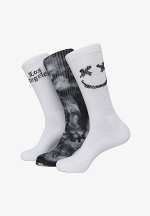 Tre paia di calze: un paio bianco con la scritta "Los Angeles", un paio bianco con una faccina sorridente e un paio nero con un motivo a vortice. Materiale in cotone misto.