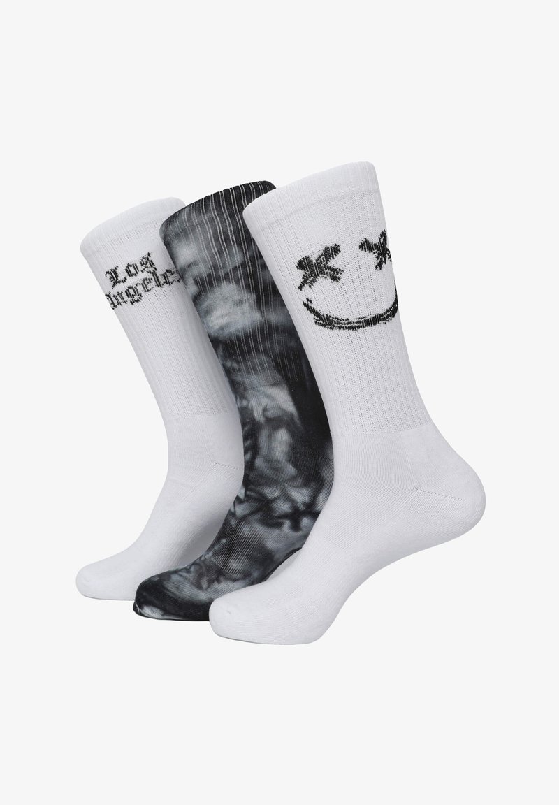 Trzy pary skarpet: jedna biała z napisem "Los Angeles", jedna biała z uśmiechniętą buźką, a jedna czarna z wirującym wzorem. Materiał mieszanka bawełny.