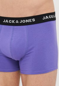 Boxeri din bumbac mov, cu un tiv elastic negru pe care este inscripționat numele brandului "JACK & JONES" în litere albe. Textură netedă.