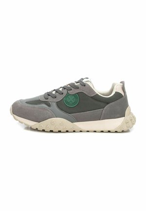 Zapatillas gris con materiales de malla y ante, forma redondeada, suela acolchada y detalle del logotipo verde en el lateral. La textura es suave y rugosa.